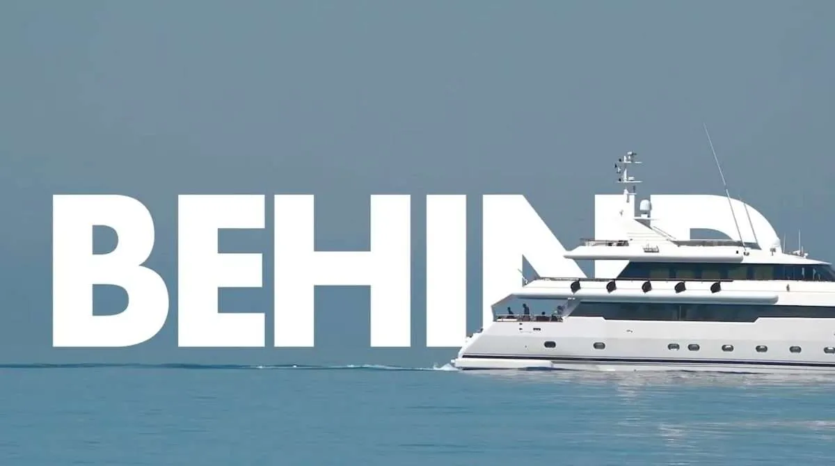Luxury yacht on open water with large 3D BEHIND wordmark set between the ocean and yacht